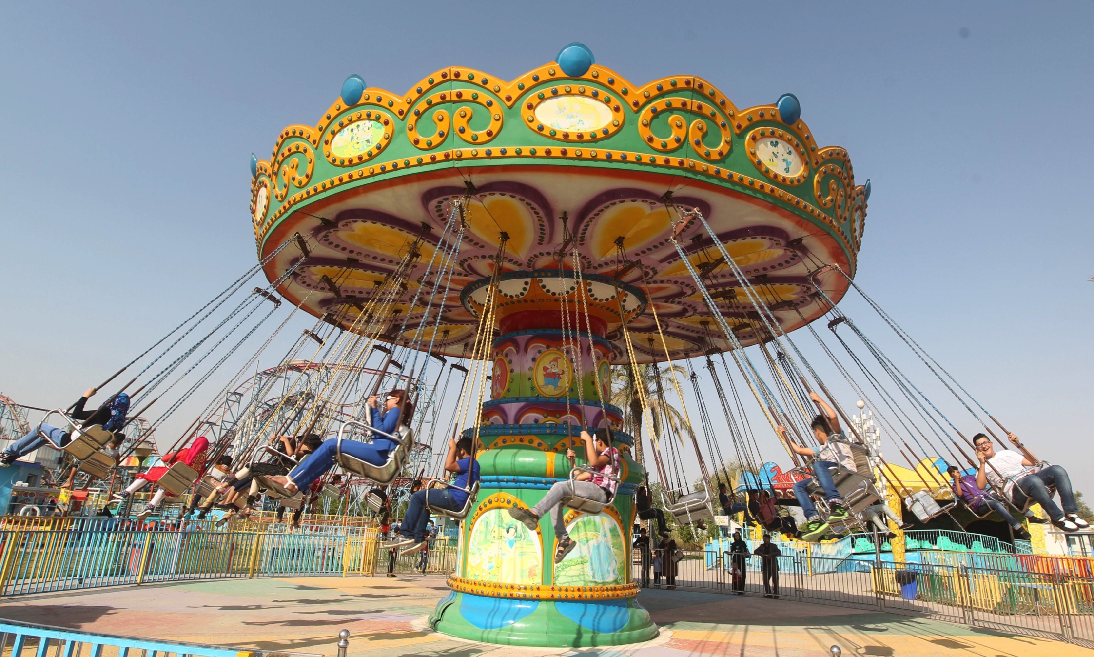 iraqis take a ride at an amusement park during the muslim holiday of eidul azha in baghdad on october 5 2014 photo afp