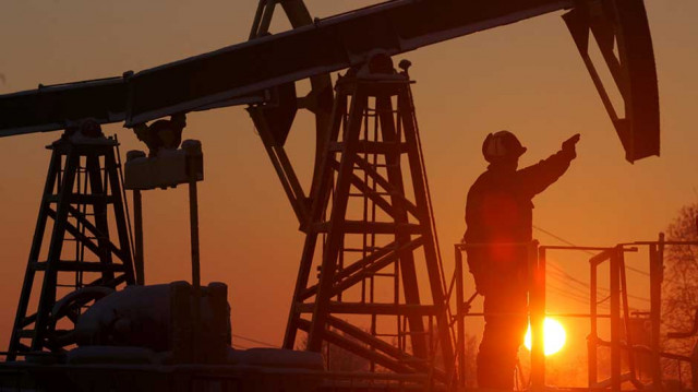 a worker stands under a derrick at a oil processing facility photo reuters a worker stands under a derrick at a oil processing facility photo reuters