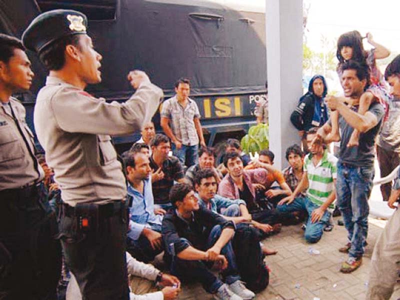 asylum seekers from afghanistan and pakistan argue with indonesian policemen at a temporary shelter in merak indonesia photo file