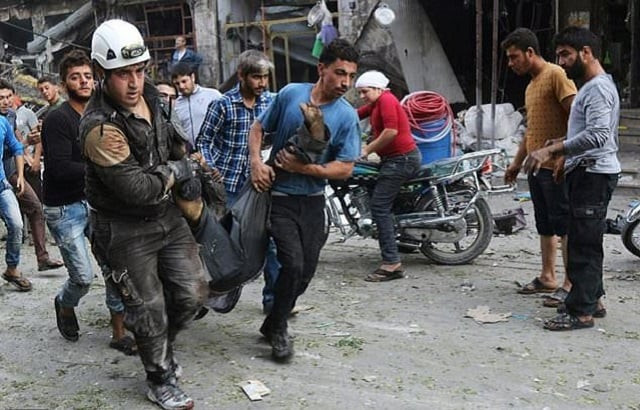 rescuers including members of the syrian civil defence also known as white helmets carry a victim of a reported air strike on a vegetable market in maaret al numan in idlib province on october 8 2017 photo afp