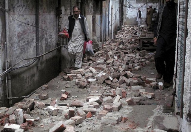 a man with his belongings walks past the rubble of a house after it was damaged by an earthquake in mingora swat pakistan october 26 2015 photo reuters hazrat ali bacha