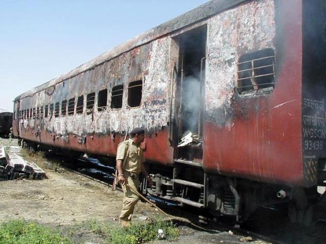 indian policeman walks towards the entrance of a carriage of a train in godhra in the western indian state of gujarat february 27 2002 photo reuters