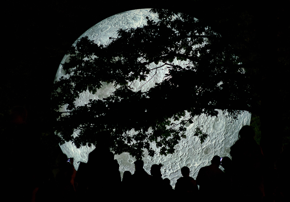 people watch a light object called quot the museum of the moon quot created by british artist luke jerram and displayed at the medical garden in bratislava during the white night festival photo afp