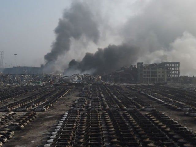 smoke billows behind rows of burnt out volkswagen cars at the site of a series of explosions in tianjin northern china on august 13 2015 photo afp