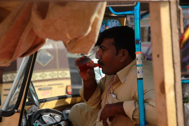 a rickshaw driver drinks chilled sherbet made from plum and tamarind to keep himself cool during the hot day photo athar khan a rickshaw driver drinks chilled sherbet made from plum and tamarind to keep himself cool during the hot day photo athar khan