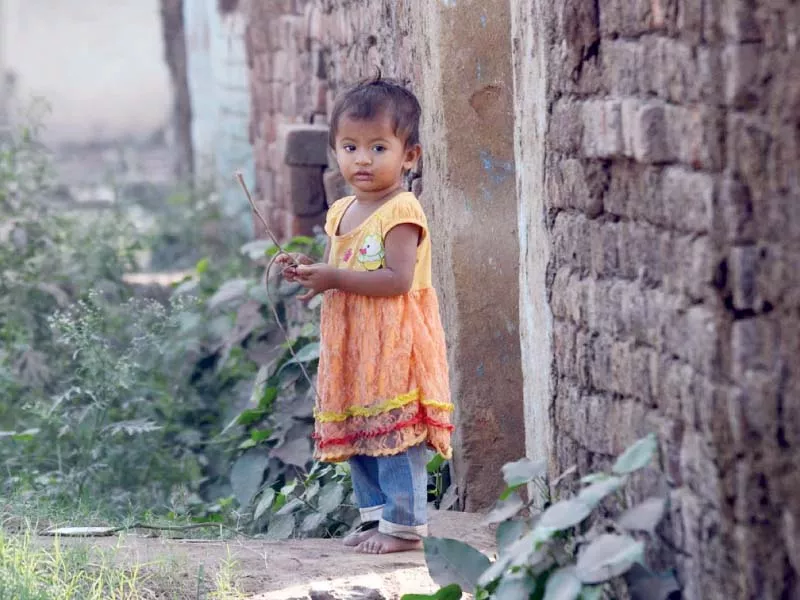 a child girl stands near her house on the occasion of international day of the girl child photo online a child girl stands near her house on the occasion of international day of the girl child photo online