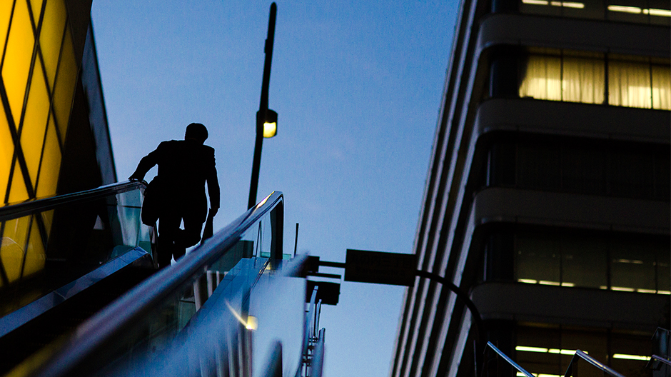 a businessman rides an escalator at a banking district photo reuters