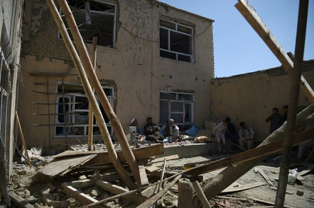 afghan residents sit in a damaged courtyard as they drink tea following a us airstrike on a house in kabul on september 28 2017 photo yahoo news
