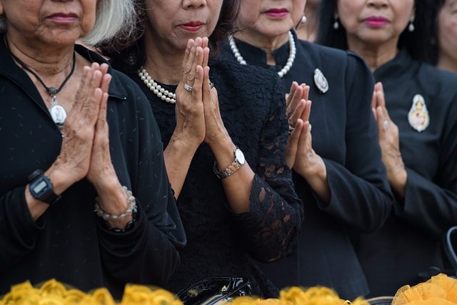 thai women pray during a ceremony led by monks in front of bangkok 039 s city hall on october 13 2017 marking one year since the death of king bhumibol adulyadej monks led sombre ceremonies across thailand october 13 to mark one year since the death of king bhumibol adulyadej as the grieving nation prepares to bid a final farewell to the beloved monarch in a spectacular cremation ceremony this month photo afp