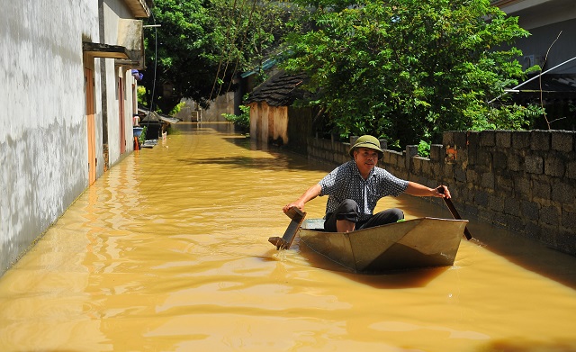 this picture taken on october 12 2017 shows a villager using a boat to cross a flooded alley at a village in the northern province of ninh binh the death toll from devastating floods and landslides in north and central vietnam has jumped to 54 officials said on october 13 in one of the deadliest weather disasters to hit the country in years photo afp