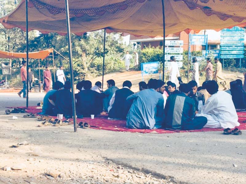 protesters sit outside the administration block at qau photo express