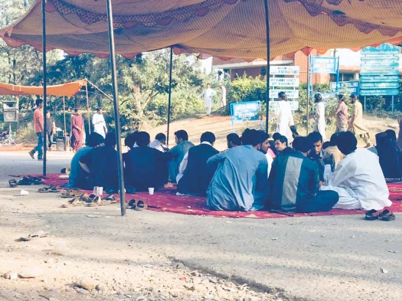 protesters sit outside the administration block at qau photo express protesters sit outside the administration block at qau photo express