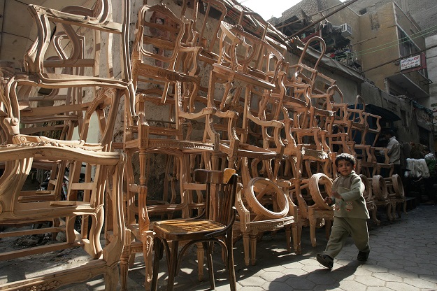 a boy walks past a furniture workshop photo reuters