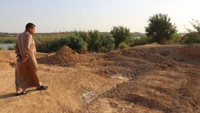 an iraqi man inspects the site of a pit containing the bodies of islamic state is fighters in the iraqi town of dhuluiyah photo afp