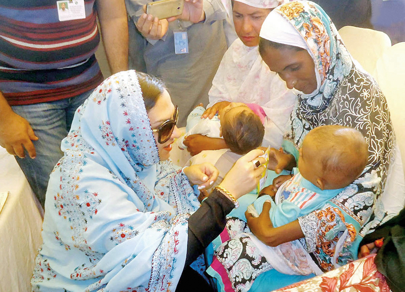 marvi memon interacts with a child during her visit in rahim yar khan photo nni