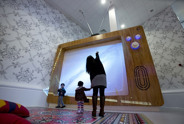 a woman and young children interact with a giant television set at the ann riches healing space for young patients at the royal london hospital in london february 22 2013 photo reuters