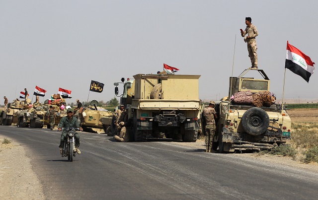 iraqi forces rest on the road as they drive towards kurdish peshmerga positions on october 15 2017 on the southern outskirts of kirkuk the presidents of iraq and iraqi kurdistan held talks to defuse an escalating crisis after a deadline for kurdish forces to withdraw from disputed positions was extended by 24 hours photo afp