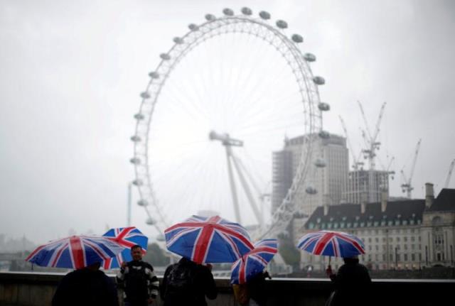 tourists carrying union flag umbrellas shelter from the rain in front of the london eye wheel in london britain august 9 2017 photo reuters