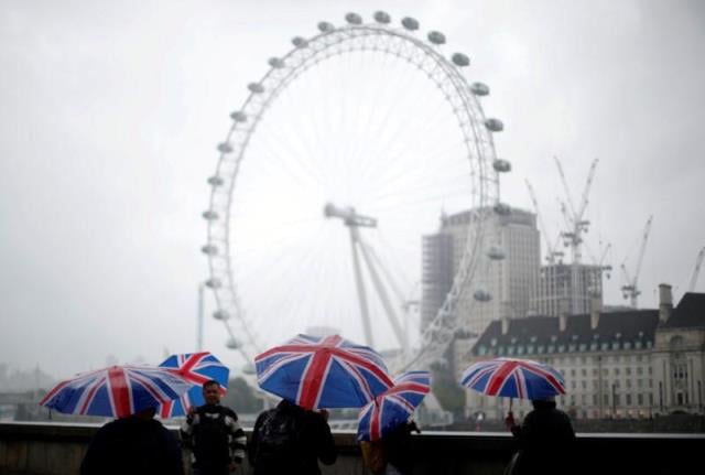 tourists carrying union flag umbrellas shelter from the rain in front of the london eye wheel in london britain august 9 2017 photo reuters