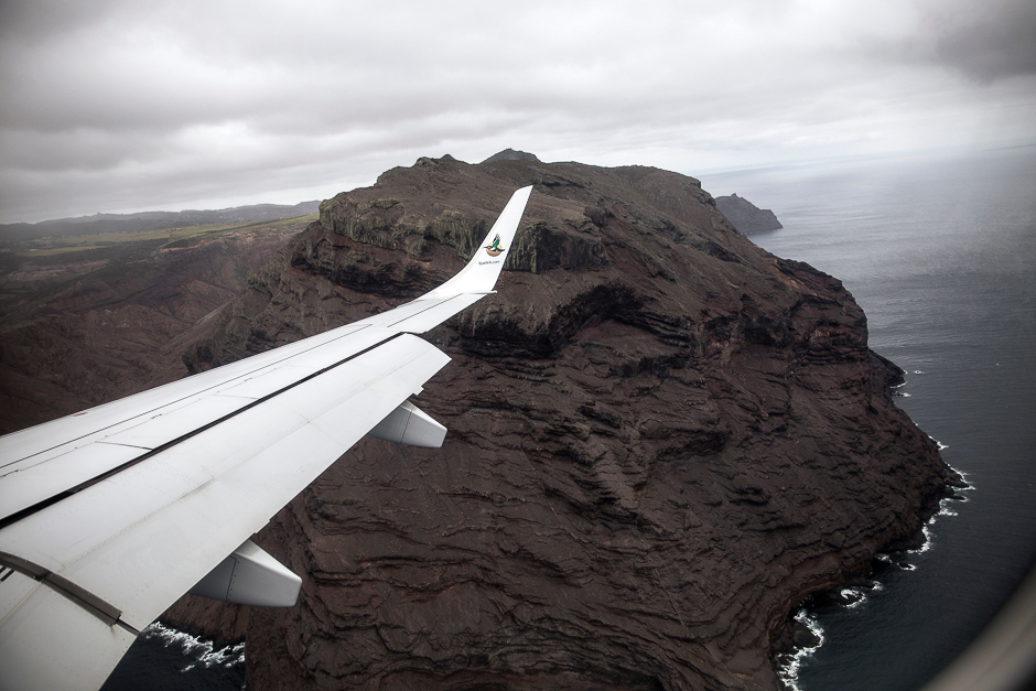 a picture taken from the inaugural first commercial flight between johannesburg and saint helena shows the cliffs of the volcanic tropical island of saint helena in the south atlantic ocean and part of the british overseas territory photo afp