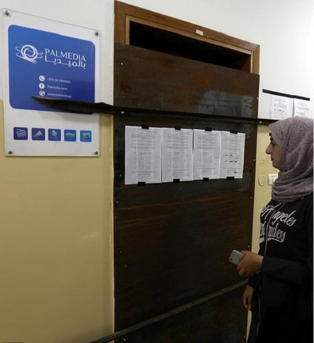 an employee of palestinian production firm palmedia arrives at work in the west bank city of nablus on october 18 2017 to find it sealed by the israeli army photo afp