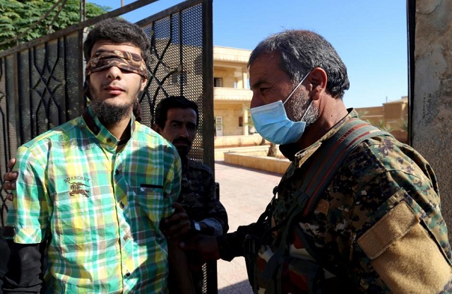 members of syrian democratic forces escort a blindfolded civilian detainee suspected to be a member of islamic state militants in raqqa photo reuters