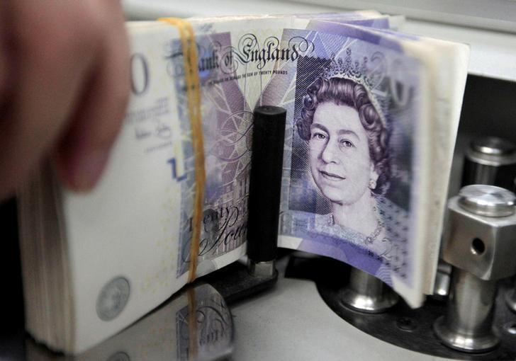 a bank employee counts pound note photo reuters