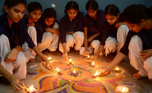 indian school girls lighting candles as they sit near a 039 rangoli 039 which is made out of coloured powder during pre diwali celebration at a school in amritsar november 12 2012 the hindu diwali festival festival of lights falls on november 13 marking the victory over evil and commemorating the time when the hindu god lord rama achieved victory over ravana and returned to his kingdom ayodhya afp photo narinder nanu