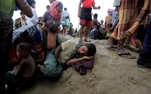 a rohingya refugee man who crossed the border from myanmar a day before sleeps as he waits to receive permission from the bangladeshi army to continue his way to refugee camps in palang khali near cox 039 s bazar bangladesh photo reuters