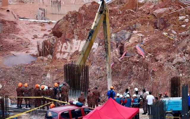 rescue workers are seen at a construction site after it was hit by a landslide in tanjung bungah a suburb of george town penang malaysia october 21 2017 photo reuters