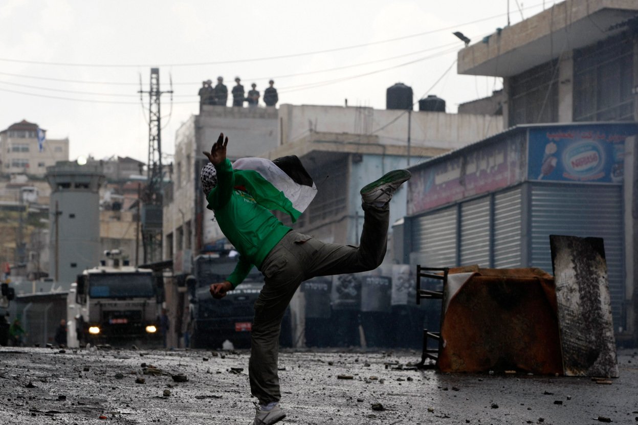 a palestinian protester throws a stone towards israeli police vehicles during clashes in shuafat refugee camp in the west bank near jerusalem on may 15 photo reuters