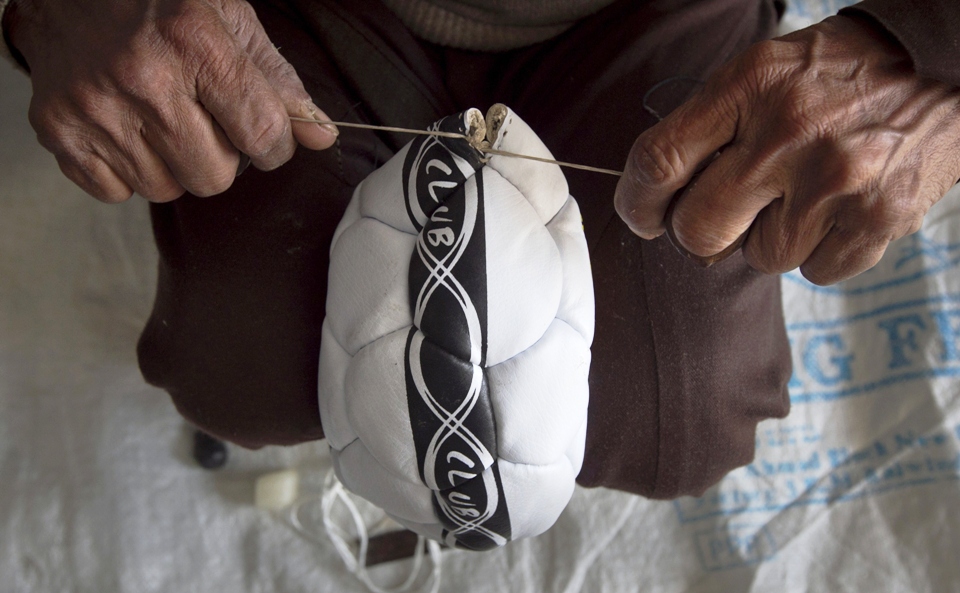 a worker finishes the final stitches on a soccer ball at a factory in sialkot photo reuters