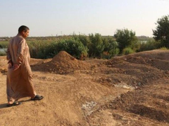 an iraqi man inspects the site of a pit containing the bodies of islamic state is fighters in the iraqi town of dhuluiyah photo afp an iraqi man inspects the site of a pit containing the bodies of islamic state is fighters in the iraqi town of dhuluiyah photo afp