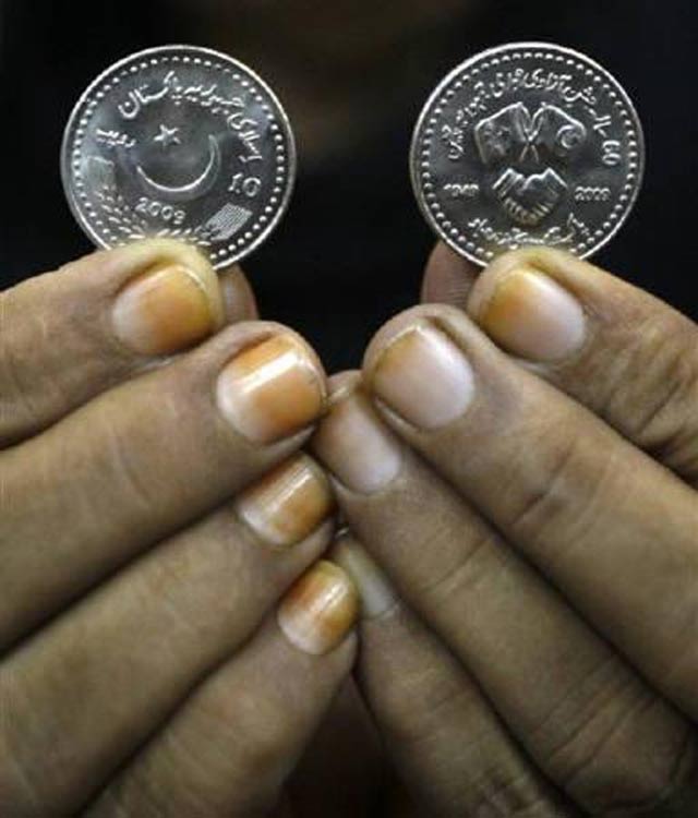 a bank employee displays 10 pakistani rupees photo reuters