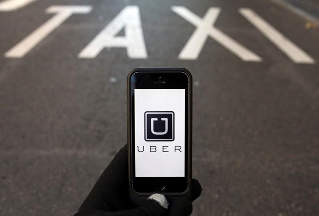 the logo of car sharing service app uber on a smartphone over a reserved lane for taxis in a street is seen in this photo illustration taken in madrid on december 10 2014 photo reuters