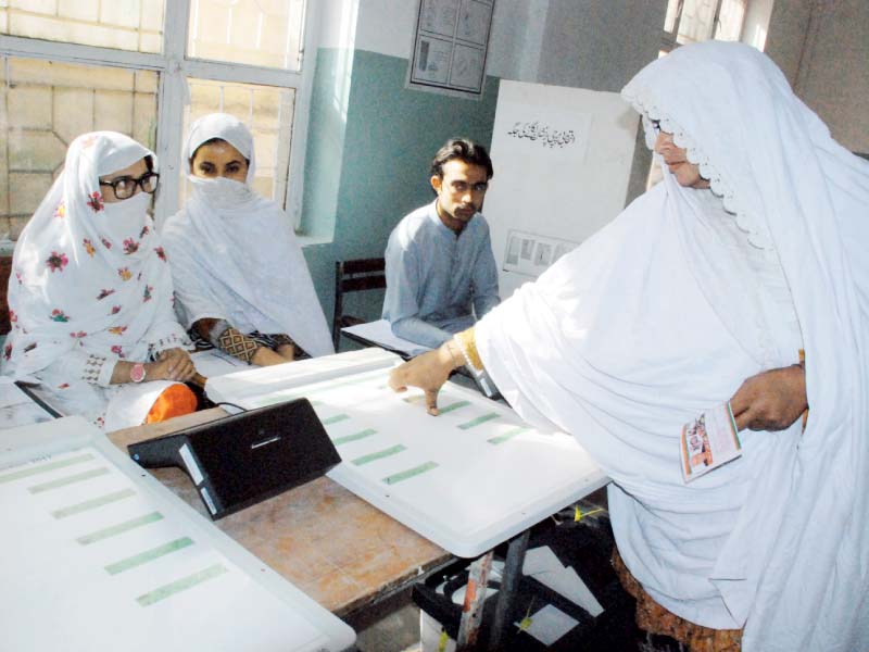 a woman uses an electronic voting machine photo iqbal haider express