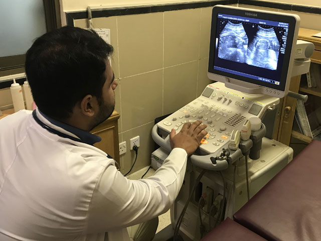 a doctor busy on an ultrasound device photo raja khalid shabbir