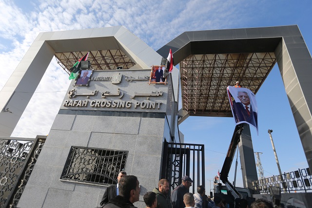 people gather as images of palestinian president mahmoud abbas and egypt 039 s president abdel fattah al sisi are seen at rafah border crossing with egypt in the southern gaza strip november 1 2017 photo reuters