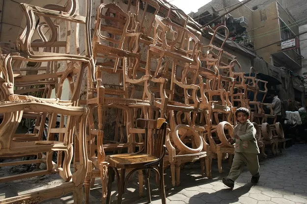 a boy walks past a furniture workshop photo reuters a boy walks past a furniture workshop photo reuters