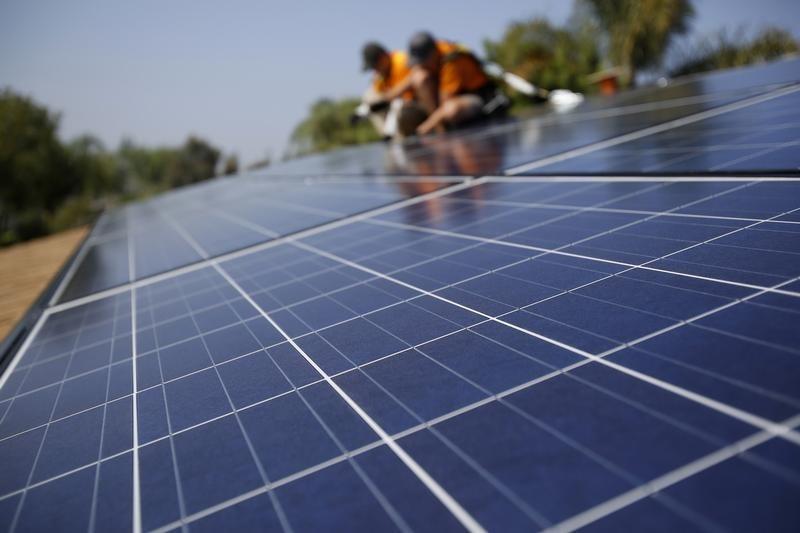 solar technicians install solar panels on the roof of a house photo reuters