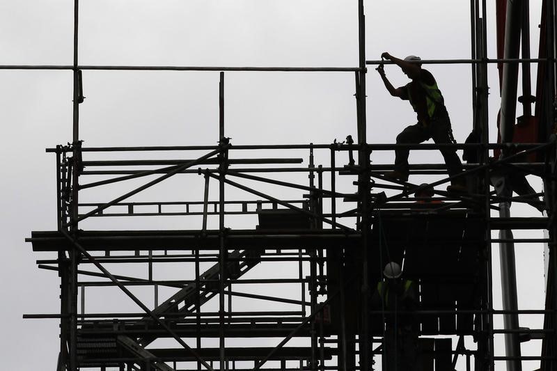 a man works on scaffolds at a construction site photo reuters