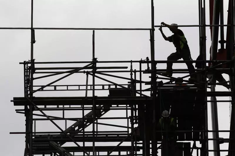 a man works on scaffolds at a construction site photo reuters a man works on scaffolds at a construction site photo reuters
