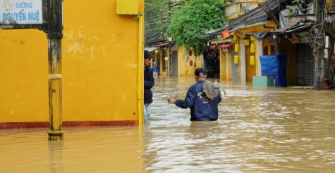 residents wade through flood waters at the central tourist town of hoi an following havy rains caused by typhoon damrey photo afp