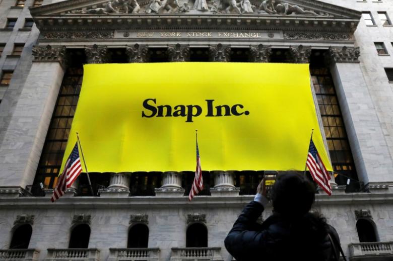 a woman photographs a banner for snap inc on the facade of the new york stock exchange nyse on the morning of the company 039 s ipo in new york city ny u s march 2 2017 photo reuters