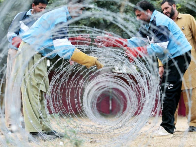 police place barbed wire for traffic management of chehlum procession photo afp