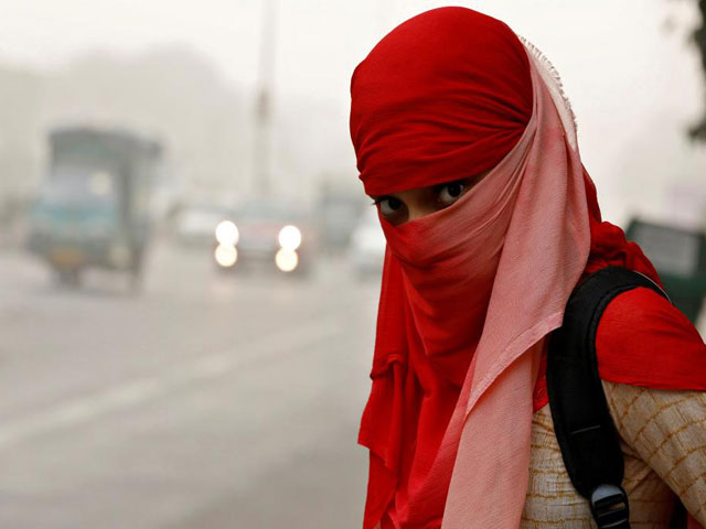 a woman wearing a scarf to cover her face looks on as she waits for a passenger bus on a smoggy morning in new delhi india november 8 2017 photo reuters