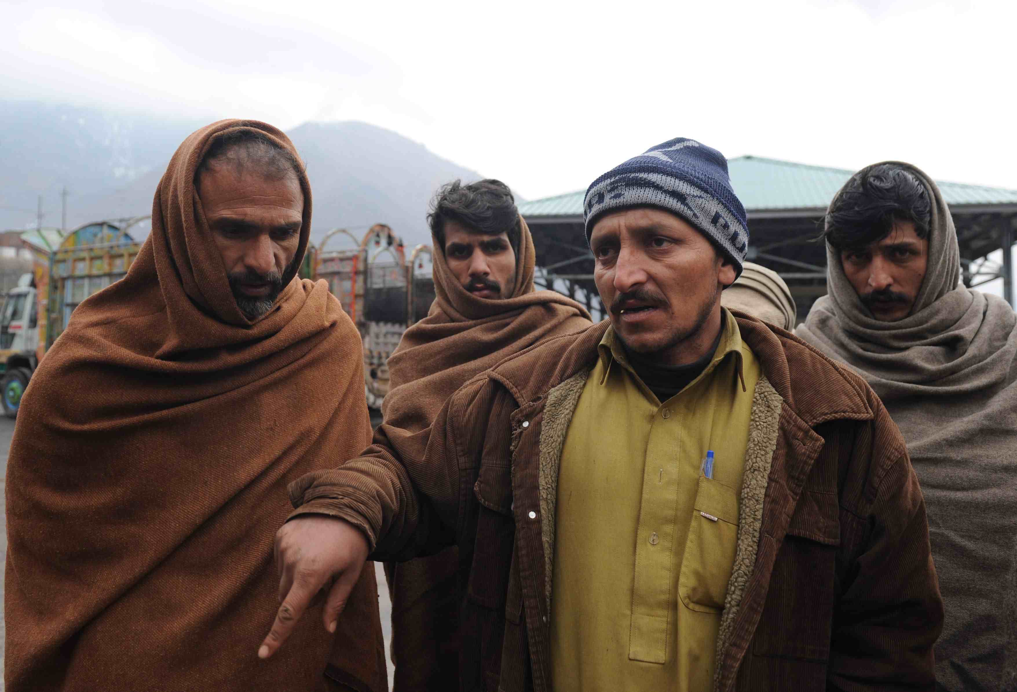 file photo stranded indian kashmiri truck drivers sit at the trade facilitation centre in chakoti just inside pakistan administered kashmir on january 24 2014 photo afp