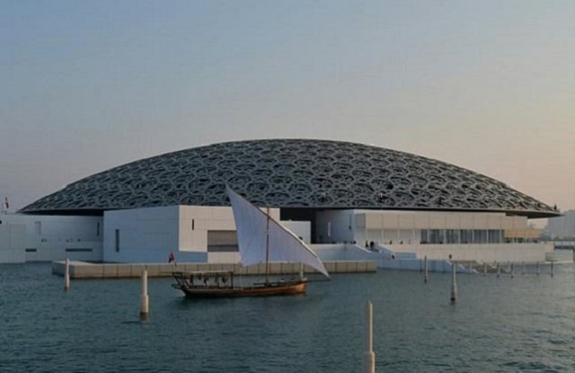 the louvre abu dhabi museum designed by french architect jean nouvel during its official opening to the public on saadiyat island in the emirati capital with a traditional dhow seen in the foreground photo afp