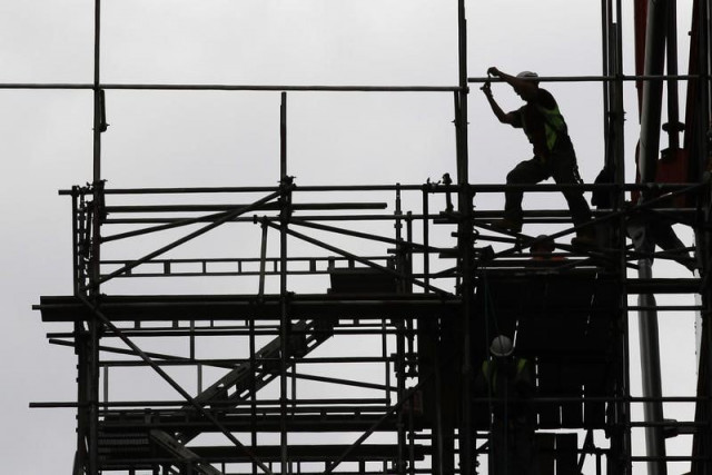 a man works on scaffolds at a construction site photo reuters a man works on scaffolds at a construction site photo reuters