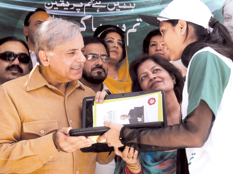 a student receives her laptop from punjab cm shahbaz sharif at fjwu photo express